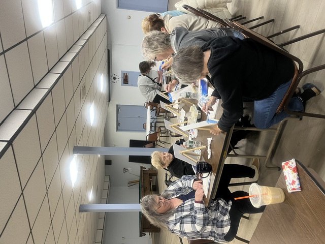 Group of seniors painting canvases